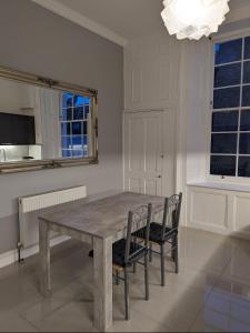 a dining room with a wooden table and two chairs at Victorian Apartment on the Famous Essex Rd in Islington in London