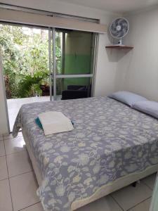 a bedroom with a bed and a window with a fan at Sítio Via Láctea - Guaramiranga in Guaramiranga