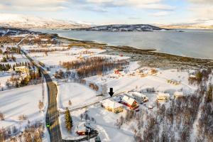 uma vista aérea de uma aldeia na neve ao lado de um corpo de água em A Modern Home in Nature's Embrace em Tromsø