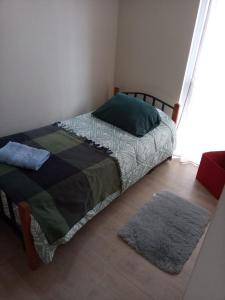 a bedroom with a bed and a rug on the floor at Departamento en Viña del Mar in Viña del Mar