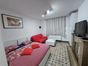 a small bedroom with a bed and a red chair at Maison LYDIE - Meublé de vacances 3 étoiles in Charleroi