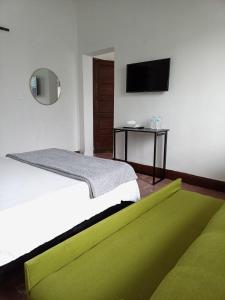 1 dormitorio con cama y alfombra verde en Confortable Loft MN 960 E Centro Mty cerca de todo, en Monterrey