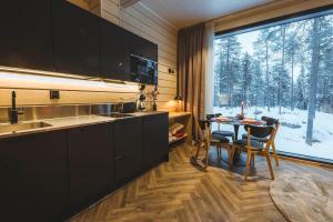 a kitchen with a table and a large window at Invisible Forest Lodge & Spa in Rovaniemi +71 photos