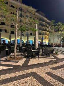 a courtyard with tables and chairs in front of a building at Cc39 -Q1 in Funchal