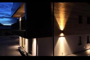 Chalet Larix Andalo Deluxe Apartments في أندالو: مبنى فيه اضاءة جانبيه