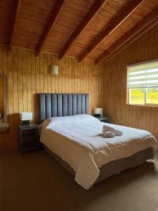 een slaapkamer met een groot bed in een houten kamer bij Casa Paraíso Chiloé - 92m2 - Quilquico in Castro