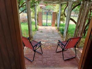Dos sillas rojas sentadas en un patio de ladrillo en Analândia: para dormir e sonhar en Analândia