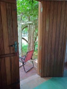una puerta abierta con una silla sentada en un porche en Analândia: para dormir e sonhar en Analândia