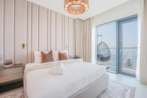 Modern 2BR High Floor Haven in Vida Dubai Marina في دبي: غرفة نوم بسرير كبير ونافذة كبيرة