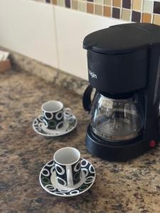 due tazze di caffè su piatti su un bancone della cucina di Surpreenda-se excelente apartamento com vista mar a Salvador