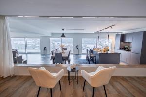 cocina y sala de estar con mesa y sillas en Visionary Hospitality - Big Premium Loft with View, Washer, Parking, Kitchen, Tub, en Dierikon