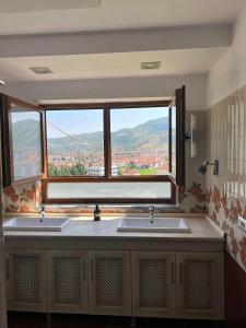 ein Badezimmer mit zwei Waschbecken und einem großen Fenster in der Unterkunft Apartament Pogradeci in Pogradec