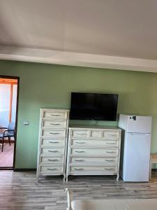ein Wohnzimmer mit einem Flachbild-TV und einem Kühlschrank in der Unterkunft Apartament Pogradeci in Pogradec