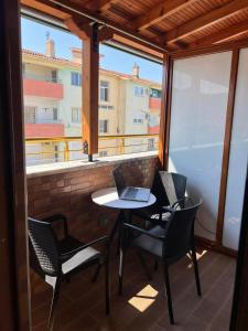 einen Balkon mit einem Tisch und Stühlen sowie einem Laptop darauf in der Unterkunft Apartament Pogradeci in Pogradec