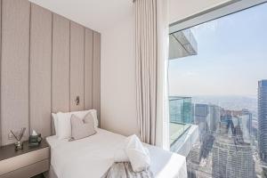 a bedroom with two beds and a large window at Modern 2BR High Floor Haven in Vida Dubai Marina in Dubai