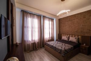 a bedroom with a bed and a brick wall at Nice and cosy villa in the heart of the city in Tbilisi City