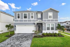 a large gray house with a white garage at 9 Bed Theatre Rm Stunner in Windsor Island in Davenport