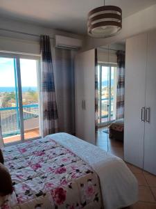 um quarto com uma cama e uma grande janela em Casa Donna Rosaria tra Etna e Taormina em Riposto