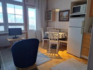 a kitchen and dining room with a table and a refrigerator at Rivitalon huoneisto Tahkolla in Tahkovuori
