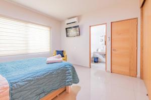 Una cama o camas en una habitación de Lujoso Condominio Tiburon a 3 Cuadras de la Playa