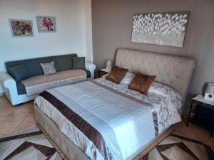 1 dormitorio con 1 cama y 1 sofá en Casa Donna Rosaria tra Etna e Taormina, en Riposto