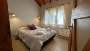 uma pequena cama num quarto com uma janela em Cabañas Las Donosas em San Carlos de Bariloche