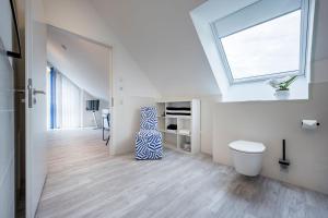 een witte kamer met een raam en een vaas op de vloer bij living TIMELESS- Design Apartment Bodensee- Friedrichshafen in Friedrichshafen +54 foto's