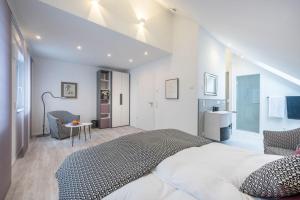 een slaapkamer met een groot bed en een tafel bij living TIMELESS- Design Apartment Bodensee- Friedrichshafen in Friedrichshafen