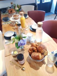 - une table avec un bouquet de viennoiseries et des bouteilles de jus d'orange dans l'établissement Maison Lavillete, à Bielle