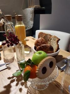 einen Tisch mit einem Teller Brot und Obst darauf in der Unterkunft Maison Lavillete in Bielle