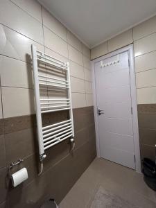 ein Badezimmer mit einer weißen Tür und einem WC in der Unterkunft Vlasic Apartmani HANA in Vršac