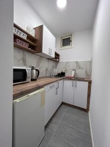 eine Küche mit weißen Schränken und einer Arbeitsplatte in der Unterkunft Vlasic Apartmani HANA in Vršac