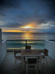 a table and chairs on a balcony with a view of the ocean at 1 Corcega Beachfront Suites in Rincon