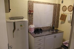 Una pequeña cocina con fregadero y refrigerador. en AP 30- Apart OH, en Ciudad del Este 16 fotos más