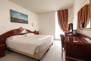 um quarto de hotel com uma cama e uma televisão em Noventa Hotel em Noventa di Piave