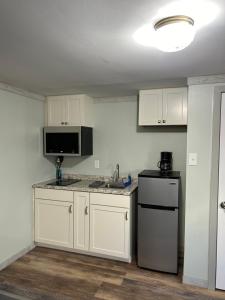 a kitchen with white cabinets and a sink and a refrigerator at Boulevard Motel in Marmora
