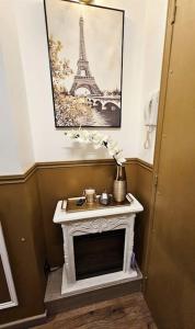 a room with a fireplace and a picture of the eiffel tower at Your hidden charm by Paris in Le Kremlin-Bicêtre