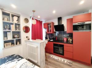 a kitchen with red cabinets and a stove at Your hidden charm by Paris in Le Kremlin-Bicêtre