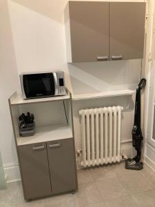 a kitchen with a microwave on a shelf and a heater at AV. CHAMPS ELYSEES 78 in Paris