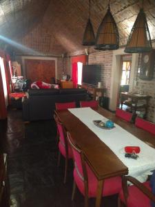 ein Wohnzimmer mit einem Tisch und rosa Stühlen in der Unterkunft La Clarita , hospedaje boutique de descanso in Francisco Álvarez