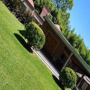 ein Haus mit einem grünen Garten mit Büschen davor in der Unterkunft La Clarita , hospedaje boutique de descanso in Francisco Álvarez