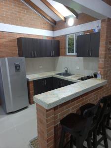 eine Küche mit einem weißen Kühlschrank und einer Ziegelwand in der Unterkunft FINCA VILLA BLANCA in Termales