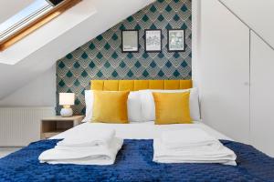 um quarto com uma cama azul e uma cabeceira amarela em The Holloway Suite - 1BR Modern Apartment em Londres