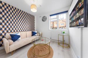 uma sala de estar com um sofá e uma mesa em The Holloway Suite - 1BR Modern Apartment em Londres
