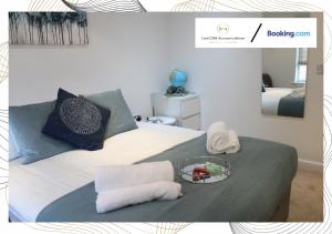 a bed with towels and a plate of food on it at Northfield Luxury Apartment in Walkly