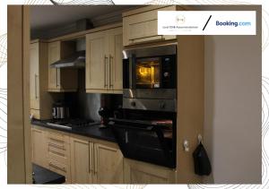 cocina con armarios de madera y horno con fogones en Northfield Luxury Apartment en Walkly