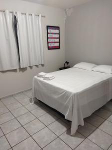 a bedroom with a large bed with white sheets at Pousada Hostel Villa Bella Mar in Natal