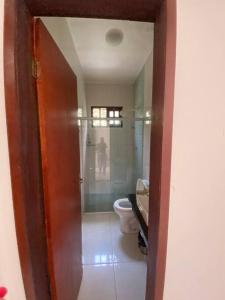 a bathroom with a toilet and a glass shower at Casa da Cascata de Crato in Crato