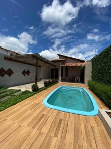 - une piscine sur une terrasse en bois avec une maison dans l'établissement Casa da Cascata de Crato, à Crato