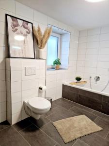 a bathroom with a toilet and a tub and a sink at Modernes Panorama-Domizil in Schömberg